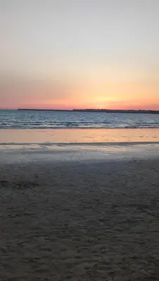 a beach at sunset with the ocean in the background at Apartamento Bajamar in El Puerto de Santa María