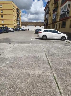 a white car parked in a parking lot next to buildings at Apartamento Bajamar in El Puerto de Santa María