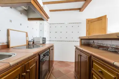 a large kitchen with wooden cabinets and a sink at Azvalia - Atarazana in El Puerto de Santa María