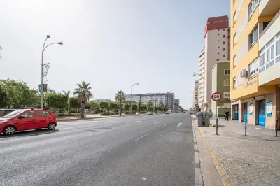 a street with a red car parked on the side of a road at Apartamento Sunset Cádiz in Cádiz