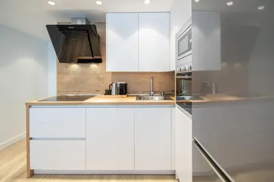 a kitchen with white cabinets and a sink at Apartamento Sunset Cádiz in Cádiz