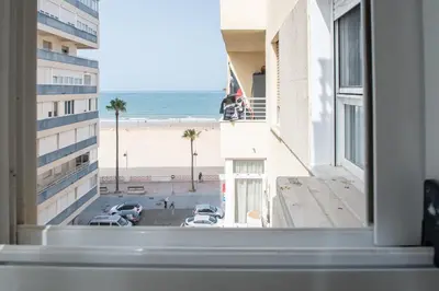 a view of the beach from a hotel window at Apartamento Sunset Cádiz in Cádiz
