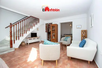a living room with two chairs and a staircase at El Anfitrión - La Cómoda in Sanlúcar de Barrameda