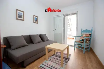a living room with a couch and a table at El Anfitrión - La Cómoda in Sanlúcar de Barrameda