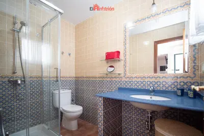 a bathroom with a sink and a toilet and a mirror at El Anfitrión - La Cómoda in Sanlúcar de Barrameda