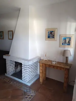 a living room with a fireplace and a wooden table at La Estrella - piscina privada in Chiclana de la Frontera