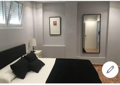 a bedroom with a black and white bed and a mirror at Disfrutar de Sanlucar de Barrameda in Sanlúcar de Barrameda
