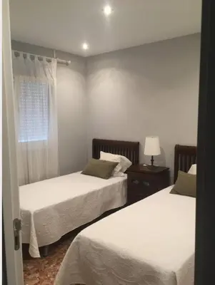 a bedroom with two beds and a window at Disfrutar de Sanlucar de Barrameda in Sanlúcar de Barrameda