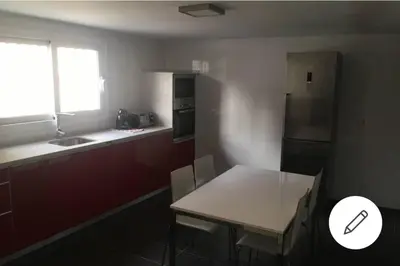 a small kitchen with a table and a refrigerator at Disfrutar de Sanlucar de Barrameda in Sanlúcar de Barrameda