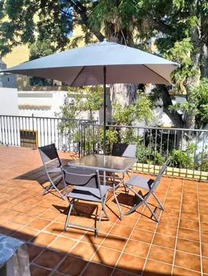 a table and chairs with an umbrella on a patio at Disfrutar de Sanlucar de Barrameda in Sanlúcar de Barrameda