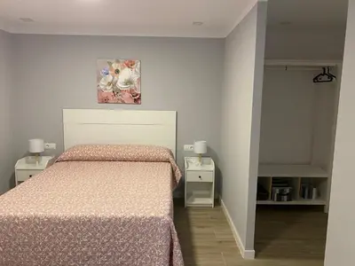 a bedroom with a bed and a painting on the wall at La Ranaverde, piscina y playa in Chiclana de la Frontera