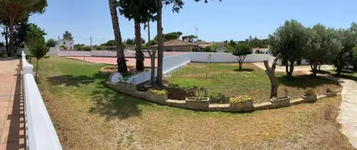 a park with trees and plants in a yard at La Ranaverde, piscina y playa in Chiclana de la Frontera