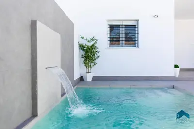 a swimming pool with a water fountain in a house at Sauz B in Chiclana de la Frontera