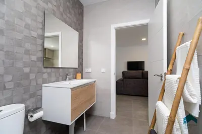 a bathroom with a sink and a toilet and a mirror at Sauz B in Chiclana de la Frontera