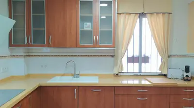 a kitchen with wooden cabinets and a sink and a window at Sherryflat Laurel in Jerez de la Frontera