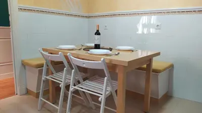a table with four chairs and a bottle of wine at Sherryflat Laurel in Jerez de la Frontera