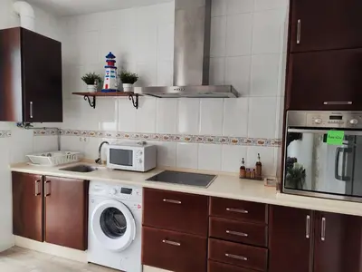 a kitchen with a washing machine and a microwave at Apartamento Cristina centro in Sanlúcar de Barrameda