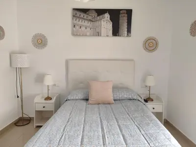 a bedroom with a bed with two night stands and two lamps at Apartamento Cristina centro in Sanlúcar de Barrameda