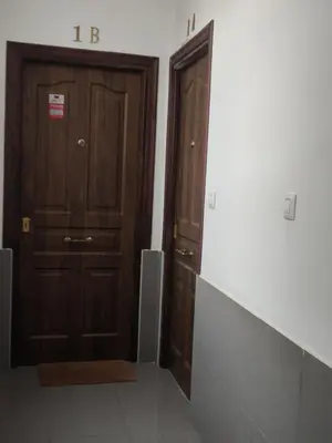 two brown wooden doors in a room with a wall at Apartamento Cristina centro in Sanlúcar de Barrameda