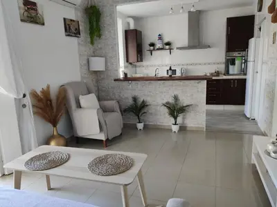 a living room with a table and a kitchen at Apartamento Cristina centro in Sanlúcar de Barrameda