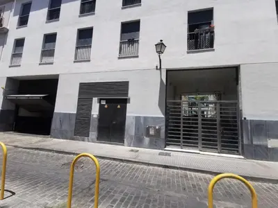 a white building with doors and windows on a street at La Gema de La Caleta in Cádiz