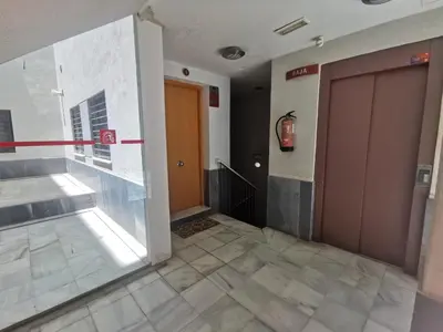 an empty hallway with a door and a tile floor at La Gema de La Caleta in Cádiz