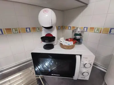 a white coffee maker sitting on top of a microwave at La Gema de La Caleta in Cádiz
