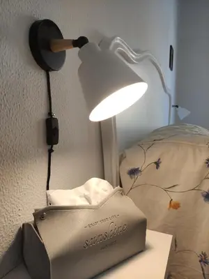 a lamp on a wall next to a bed at El pisito Sanlúcar in Sanlúcar de Barrameda