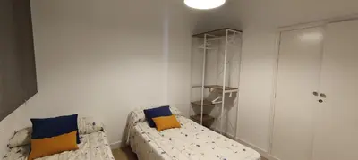 a living room with a couch with blue and yellow pillows at El pisito Sanlúcar in Sanlúcar de Barrameda