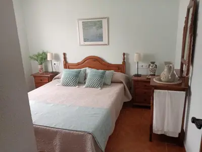 a bedroom with a large bed with blue pillows at Casa El Veranito in Chiclana de la Frontera