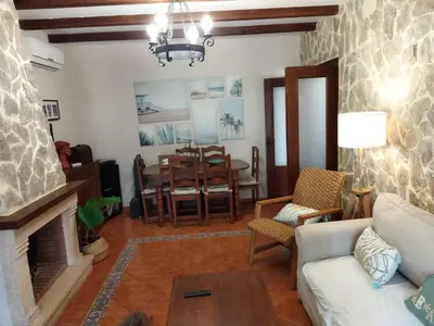a living room with a fireplace and a dining room at Casa El Veranito in Chiclana de la Frontera