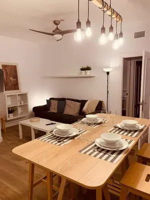 a living room with a large wooden table with plates on it at Chipiona Acogedor LA in Chipiona