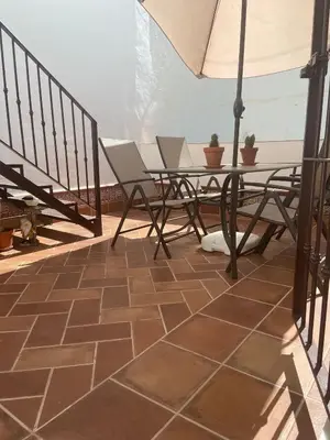a patio with a table and chairs and an umbrella at MyChoice Blas Infante in Rota