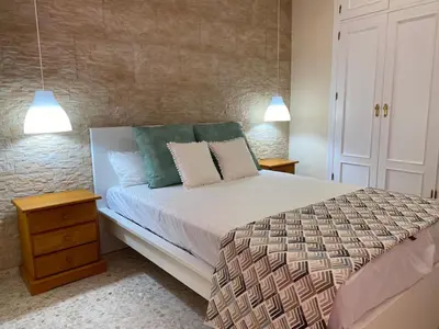 a bedroom with a bed with two night stands and two lamps at MyChoice Blas Infante in Rota