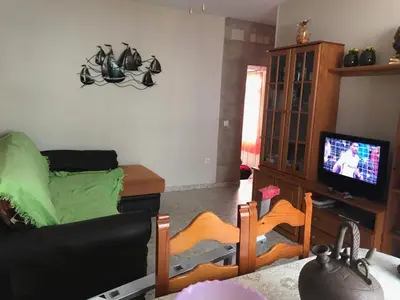 a living room with a couch and a television at MyChoice Blas Infante in Rota