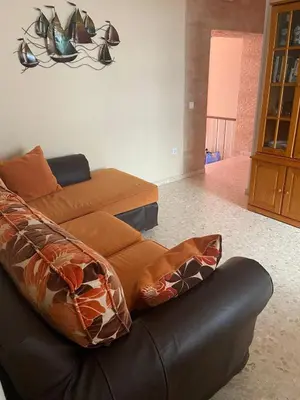a living room with a leather couch and a chandelier at MyChoice Blas Infante in Rota