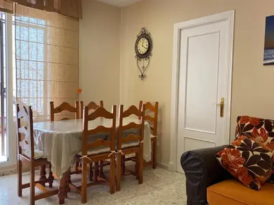 a dining room with a table and a clock on the wall at MyChoice Blas Infante in Rota