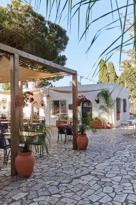 a patio with tables and chairs and a building at TAIGA Conil in Conil de la Frontera