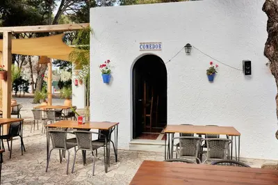 a restaurant with tables and chairs in front of a door at TAIGA Conil in Conil de la Frontera