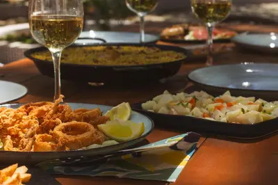 a table with plates of food and glasses of wine at TAIGA Conil in Conil de la Frontera