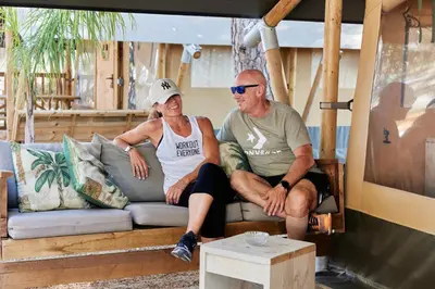 a man and a woman sitting on a couch at TAIGA Conil in Conil de la Frontera