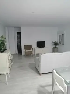 a living room with white furniture and a tv at Hormaza Chiclana in Chiclana de la Frontera
