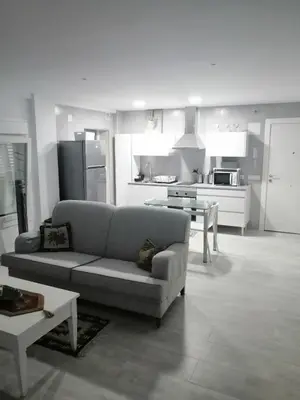 a living room with a couch and a kitchen at Hormaza Chiclana in Chiclana de la Frontera
