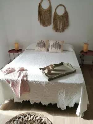 a bedroom with a white bed with two baskets on the wall at MEDINA BLUE - CASITAS CON ENCANTO in Medina Sidonia