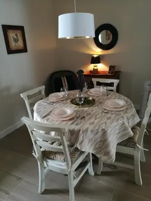 a white dining room table with plates and wine glasses at MEDINA BLUE - CASITAS CON ENCANTO in Medina Sidonia