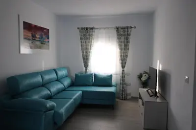 a living room with a blue couch and a window at Naveros Bajo in Los Naveros