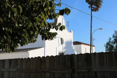 a white building behind a wooden fence at Naveros Bajo in Los Naveros