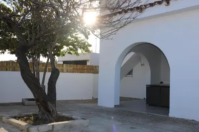 a tree in front of a white wall with an archway at Naveros Bajo in Los Naveros