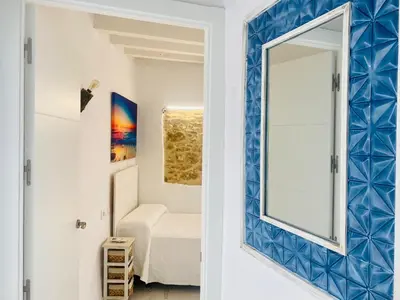 a mirror in a blue and white room with a bedroom at Luz, aire y mar Grupo AC Gestion in Cádiz
