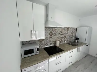 a white kitchen with a sink and a microwave at Buhardilla en calle Ancha, pleno centro in Sanlúcar de Barrameda